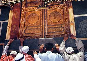 Prilgrim holding the threshold of the Holy Ka'bah's door